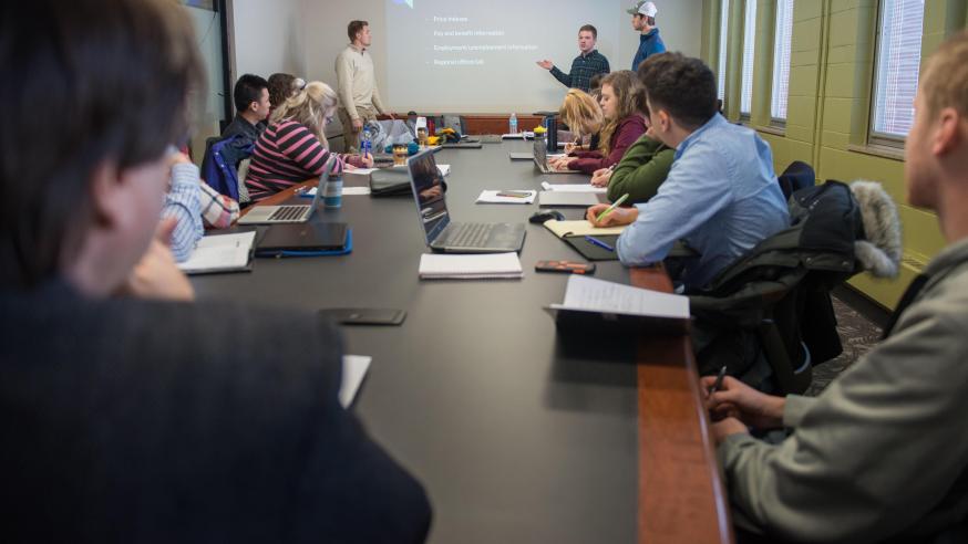 Students in an economics class watch a presentation.