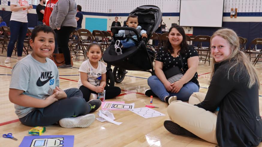Blugold Halle Smith (right) works with an Eau Claire-area family on an art project during the first UW-Eau Claire campus-community Spanish Literacy Event.