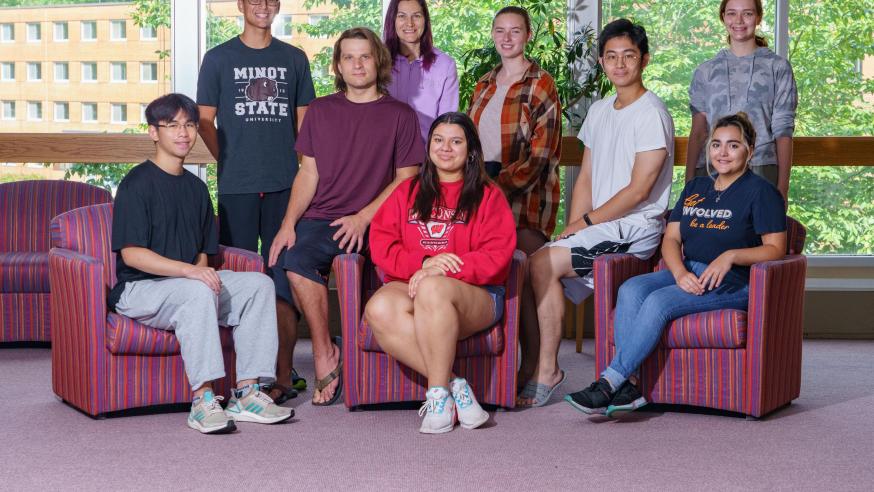 Group of students mixed genders, sitting and standing in library breezeway