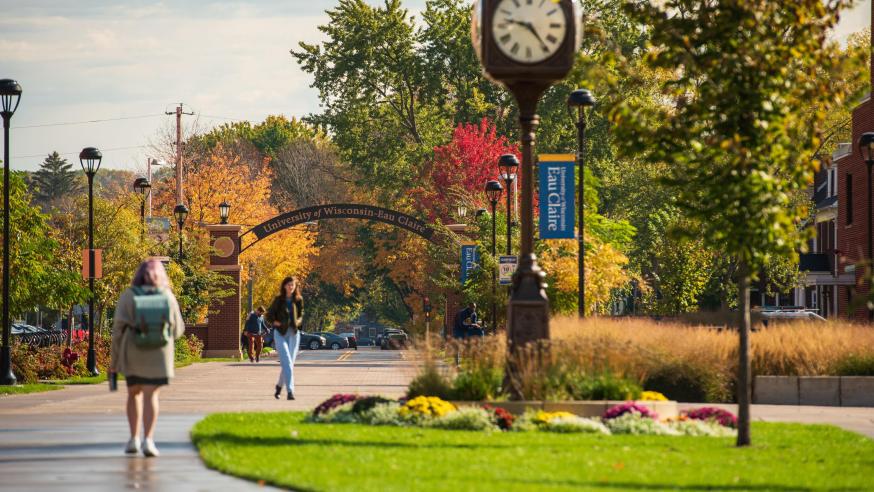 Students walk on Garfield Ave with UW Eau Claire arch in background.