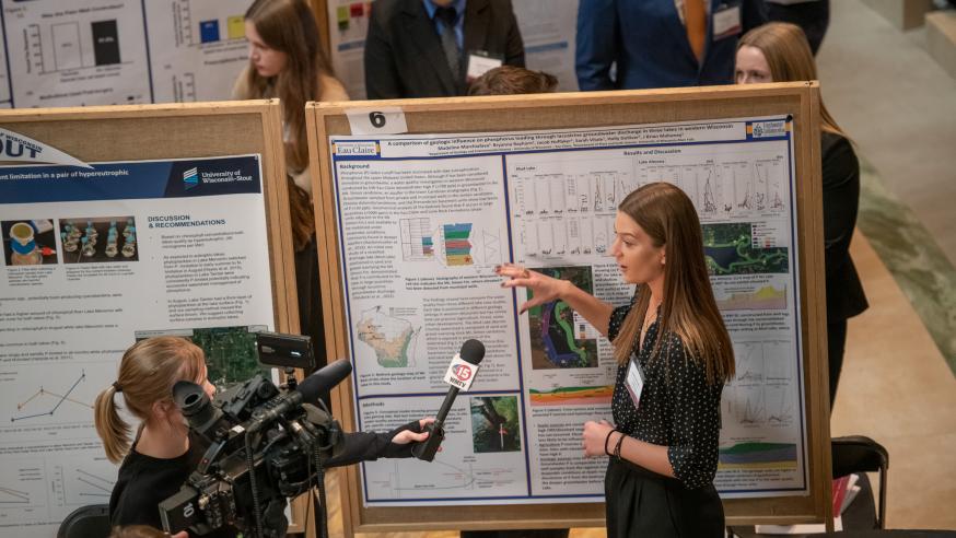 Female student being interviewed by TV crew talking about her research project