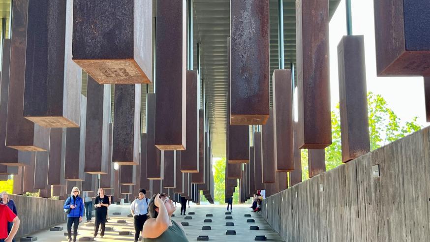People walking through metal blocks of National Memorial for Peace and Justice