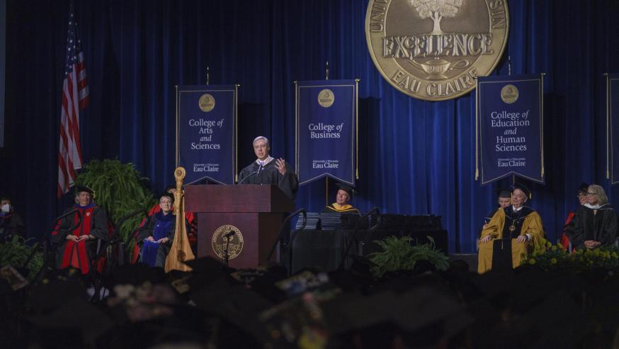 male alumni awardee giving the "Charge to the Class" address in ceremony