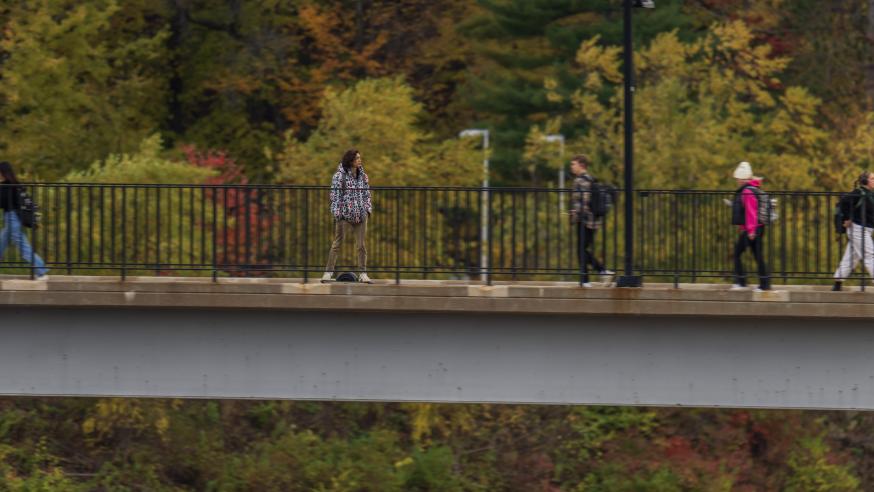 one wheel device rider on the UWEC footbridge on a fall day