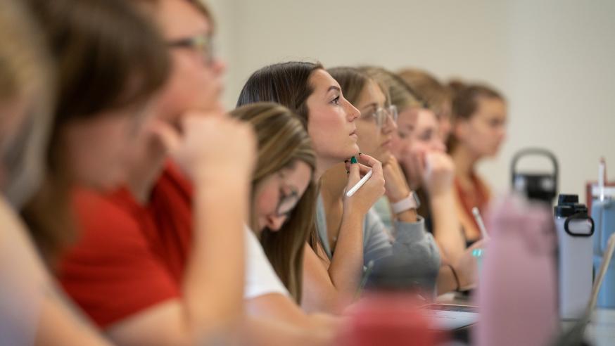 full classroom of students all facing the front of the lecture hall