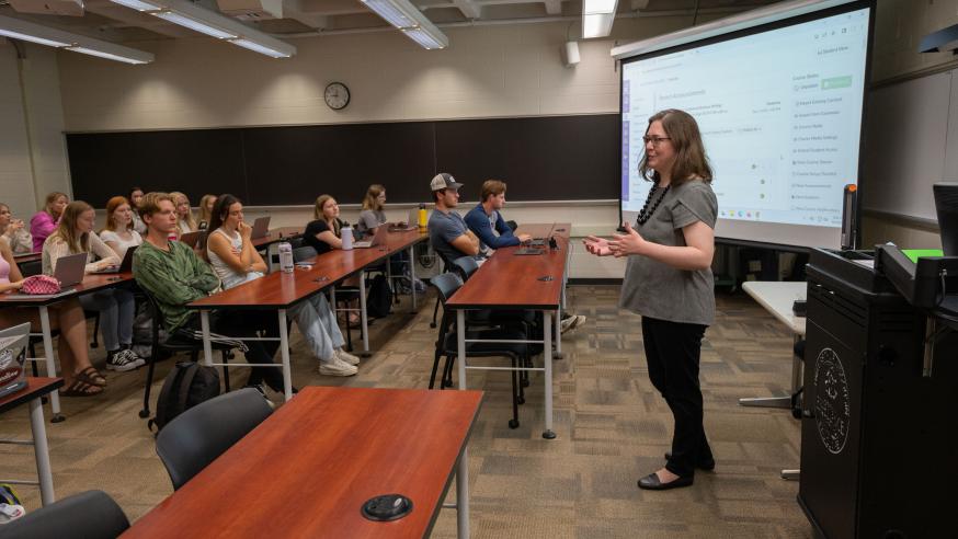 students in a lecture class, female instructor at the front