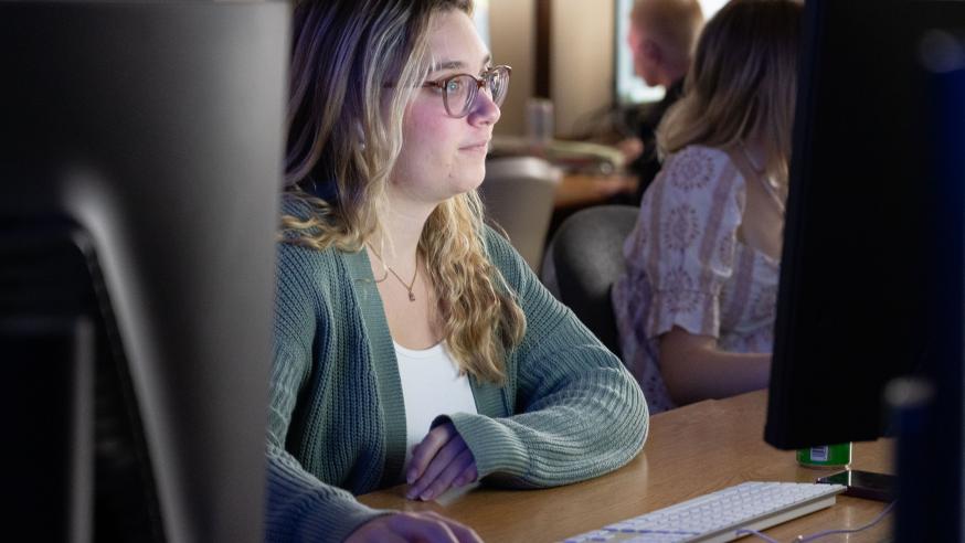 graphic design student in class at a Mac computer