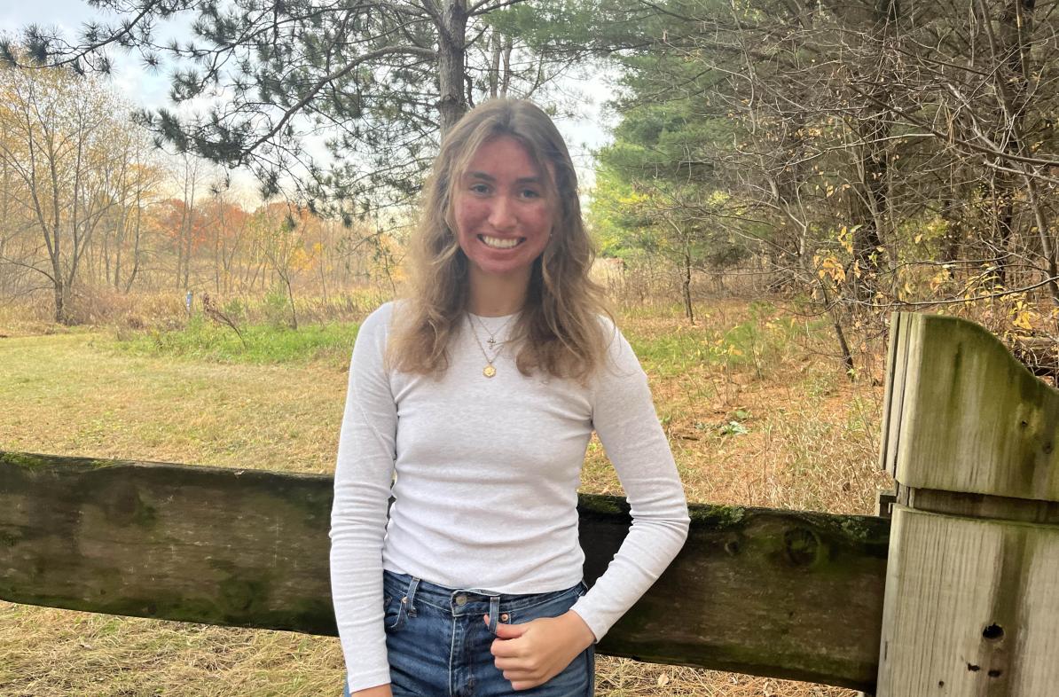 Jasmine Pearson stands in front of a fence.