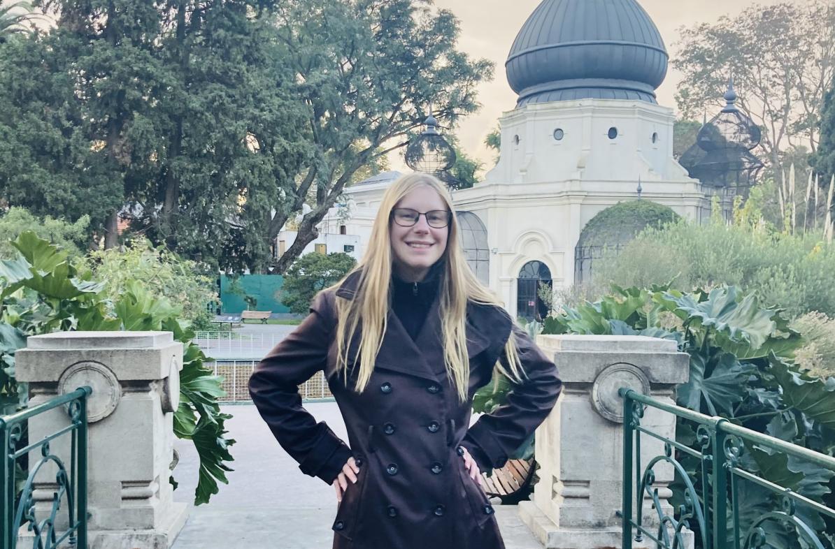 Student poses in front of a building.