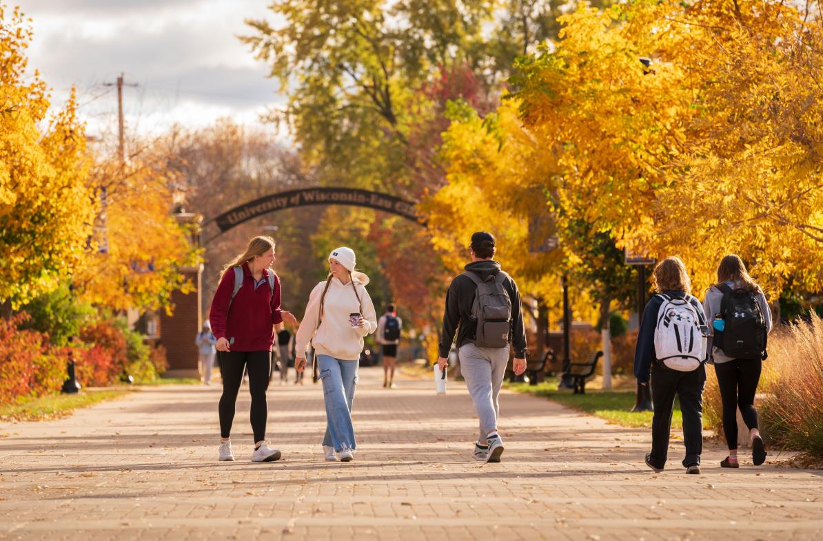 Students walk by the archway on a fall day in between classes
