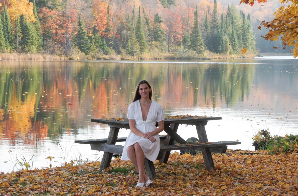 Student at a bench in front of a lake