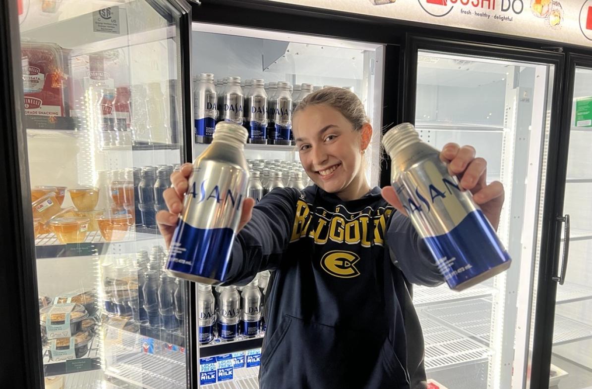Student poses with new Dasani aluminum water cans