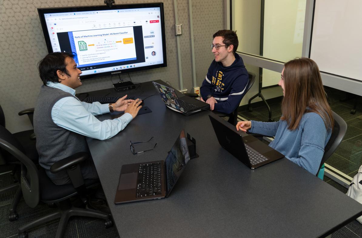 UW-Eau Claire faculty member and two students meeting