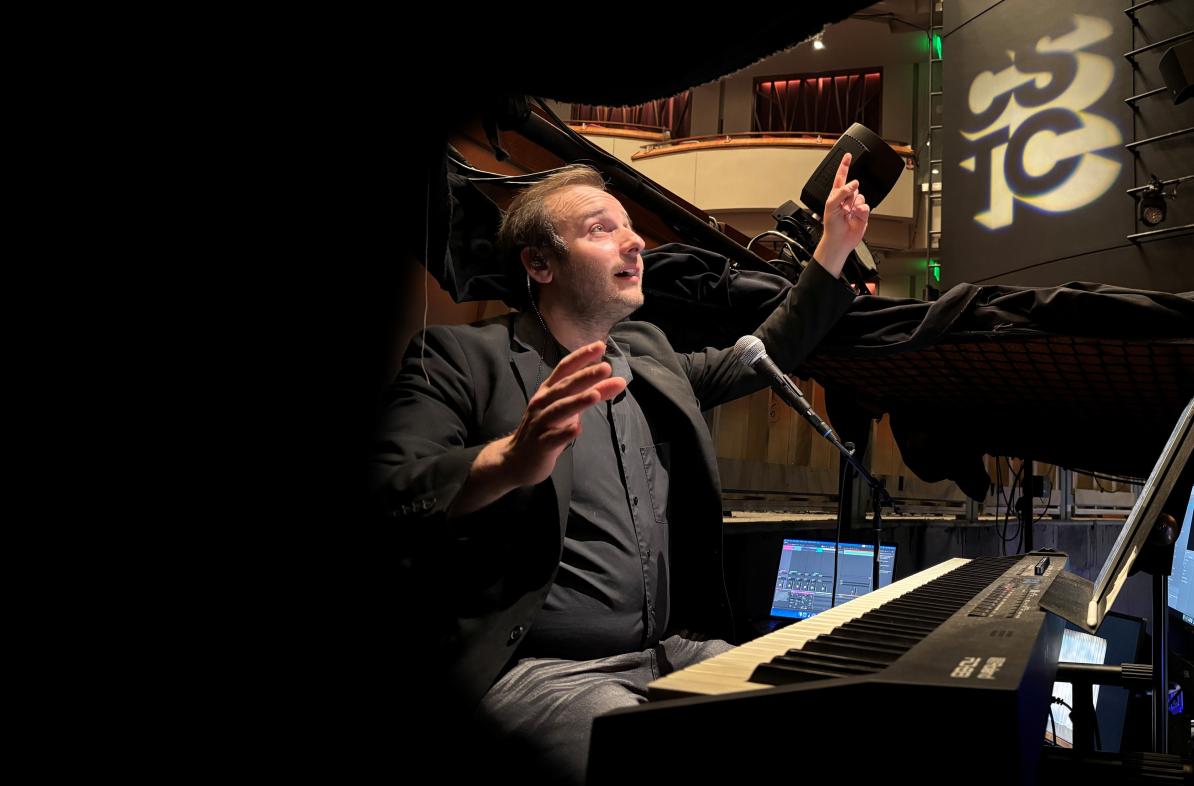 Miles Plant conducting in sound booth of a production 