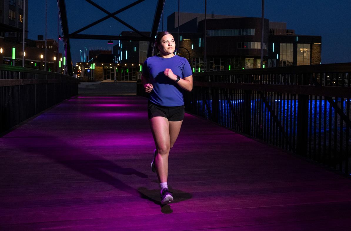 A student runs downtown Eau Claire during a summer evening.