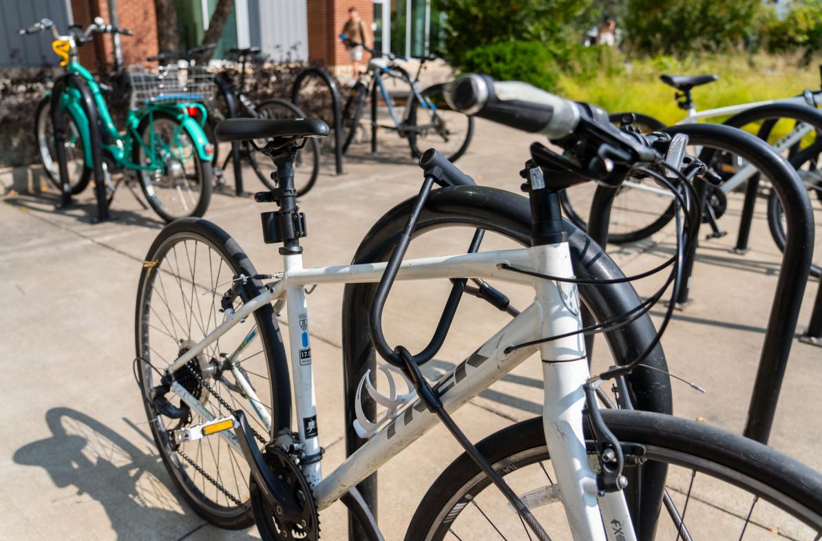 White bike in a campus bike rack locked up 