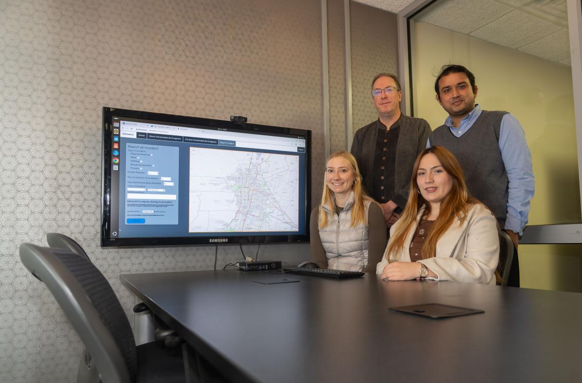 research team group shot in computer lab, two seated, two standing 