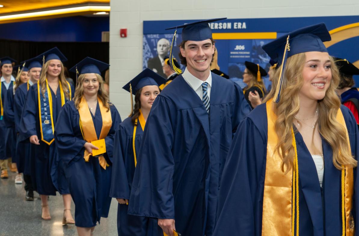 Students lined up for Commencement smile at camera.