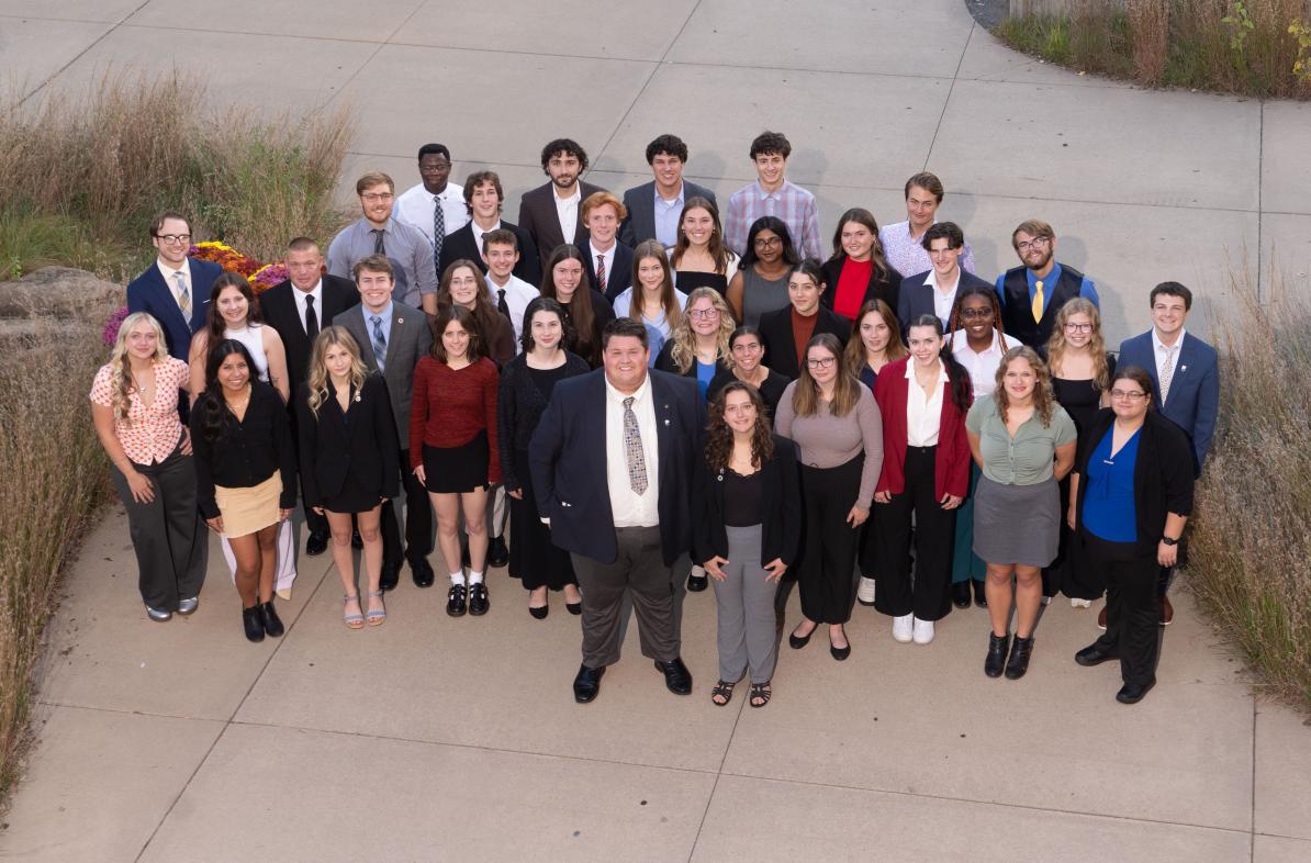 A large group of students who represent Student Senate smile up at the camera. 