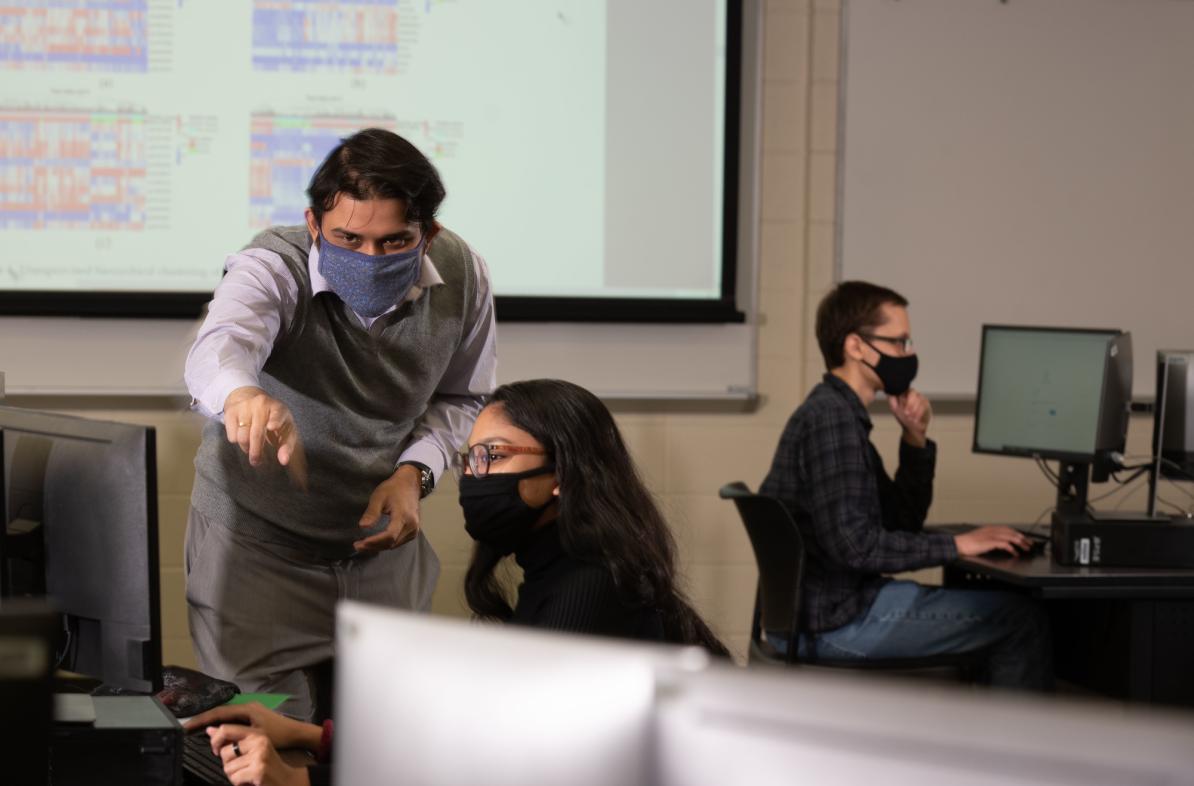 Dr. Gomes works with student in computer lab