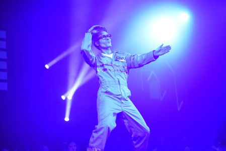 A performer gestures on stage.