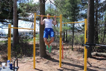 Student does pull ups on vita course equipment