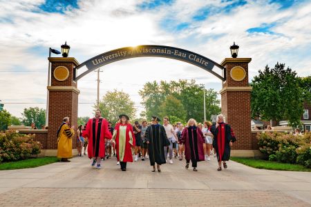 Deans of the colleges walking incoming freshman through the arch.