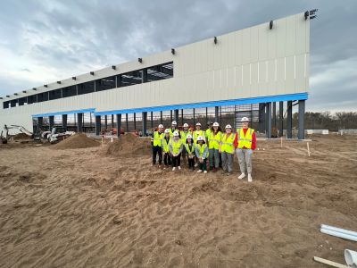 A group of students stands in front of the Sonnentag building while it is still under construction.
