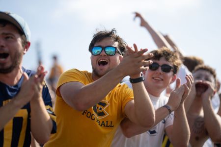 A close up shot of Blugolds cheering and clapping during the Homecoming football game.