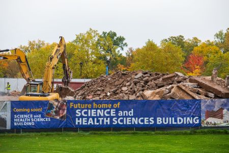 A torn down building illustrates the start of the construction of the new Science and Health Sciences building.