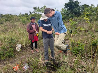 Field researching taking core samples of ground near shore