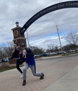 Jayson Coleman and friend posing in front of the UW-Eau Claire arch