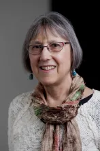 A woman with glasses smiling