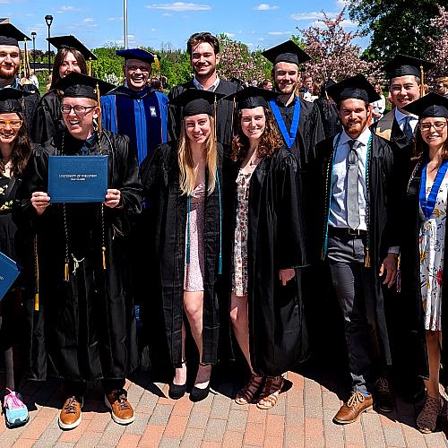 group of geology graduates with Dr. Scott Clark, all in gowns 