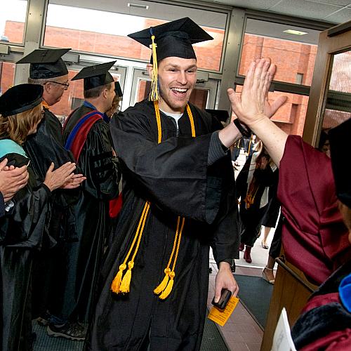 High fives for Dean Manning from male COEHS grad 