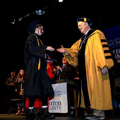 Chancellor Schmidt shaking graduate hand, Barron campus 
