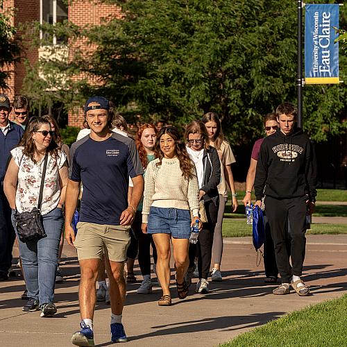 student leading a tour group outdoor on campus 
