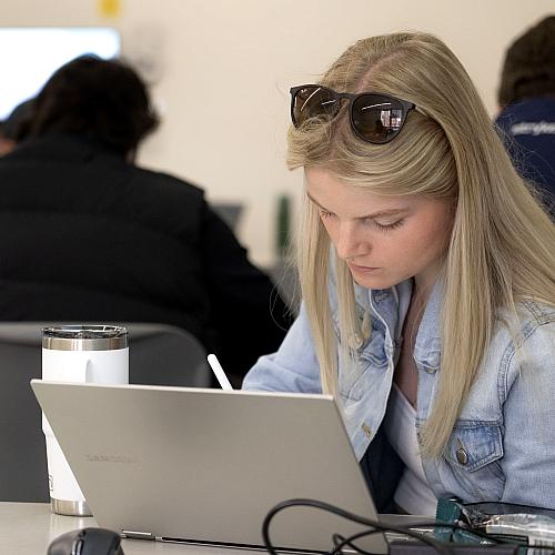 student at a laptop in a classroom 