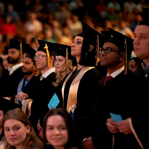Graduates stand ready to receive their diploma 