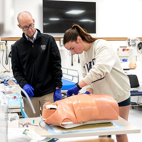 A student works on a simulation with a Mayo Clinic physician in a medical facility.