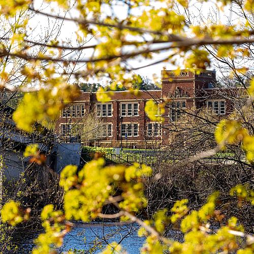 A shot of Schofield Hall during the fall with fall leaves framing the shot.