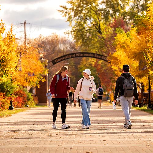 Students walk by the archway on a fall day in between classes