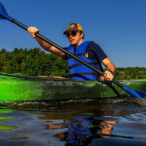 A student kayaks across the Chippewa River