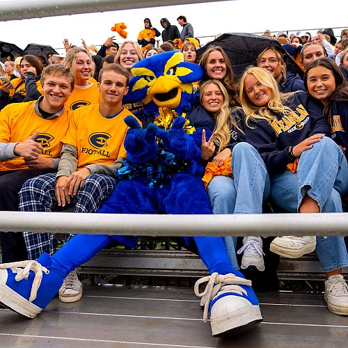 Blu poses with a bunch of Blugolds in the stands during UWEC's first football game of 2025.