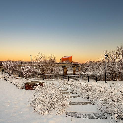 The sun sets over the Bridge with the surrounding land covered in snow.
