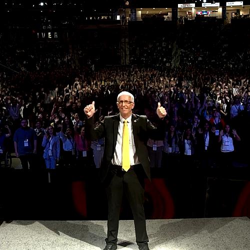 Dr. Michael Carney gives the thumbs up to the camera while in front of hundreds of conference attendees.